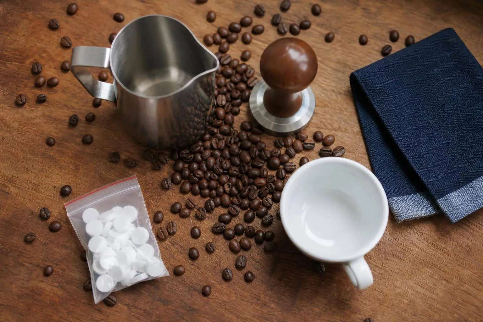 Kaffeebohnen, Reinigungsmittel und Wasserfilter als Zubehör nebeneinander